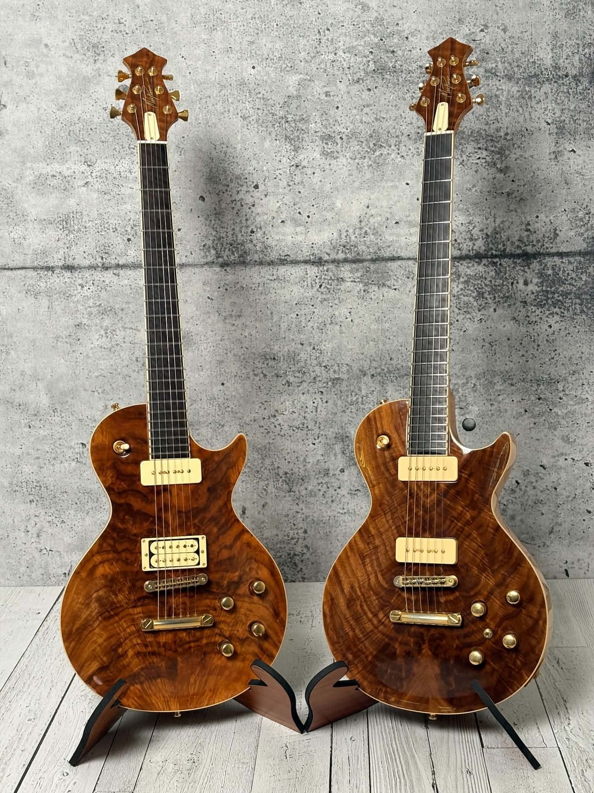 Two boutique walnut-top guitars on stands